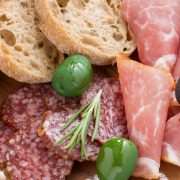 assorted Italian antipasti - deli meats, olives and bread, close-up, top view